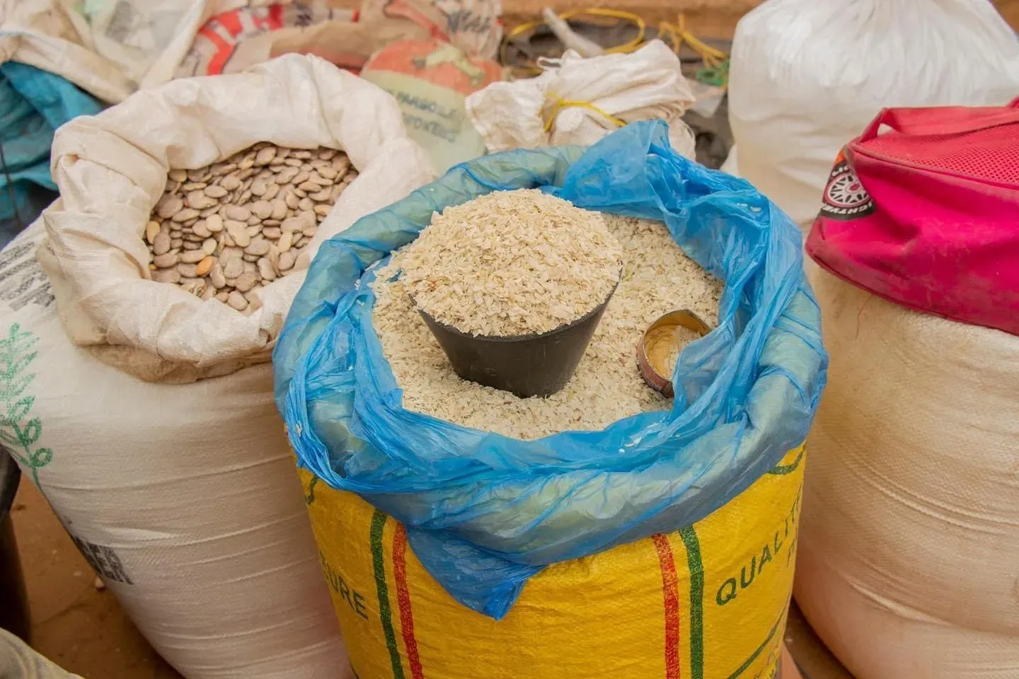 Mesure traditionnelle de produits sur un marché en Guinée